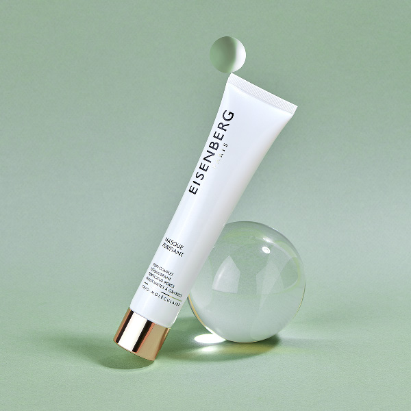 mattifying skincare leaned against a transparent bubble on a light green backgound